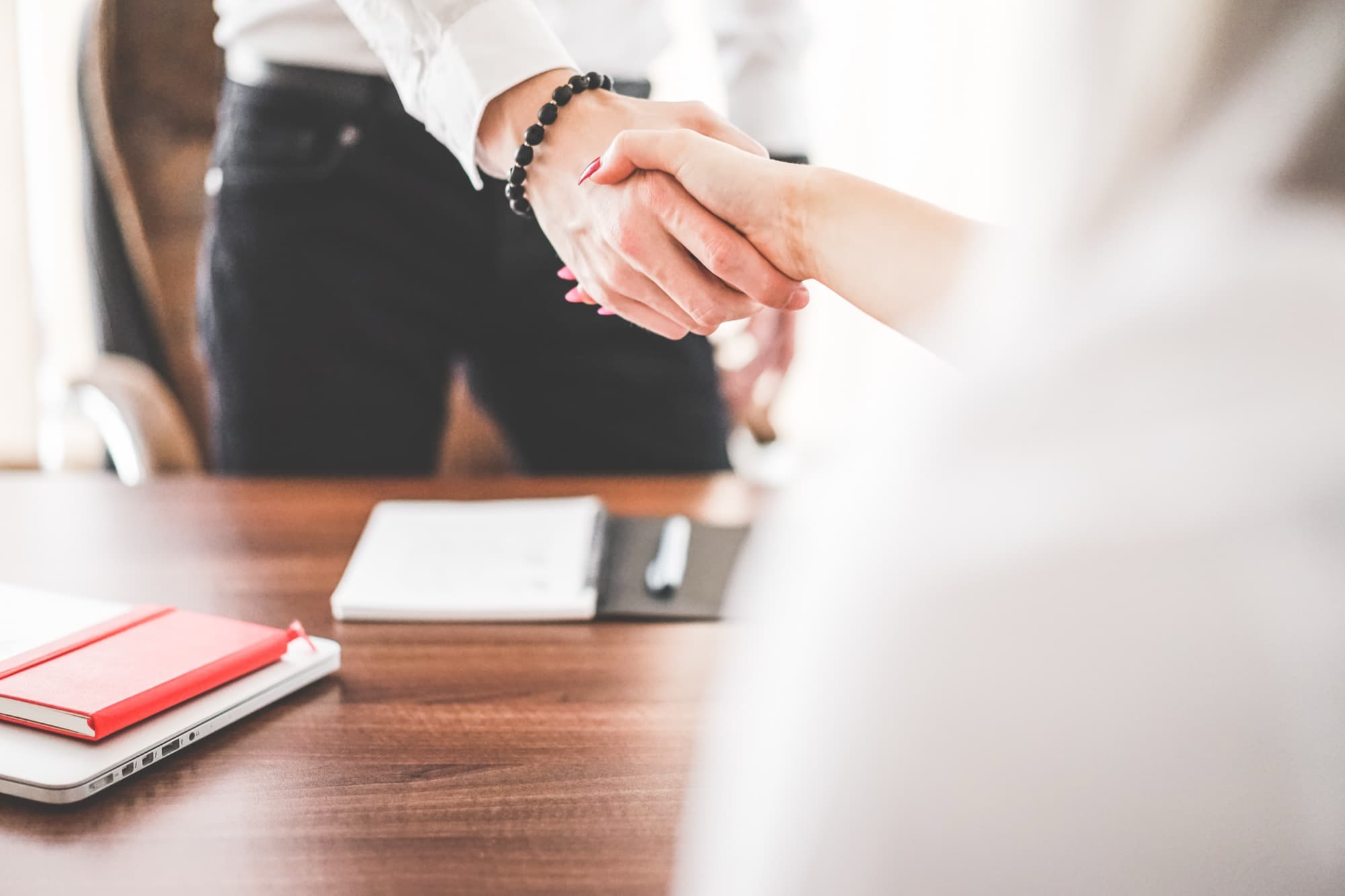 Business colleagues shaking hands in a work office